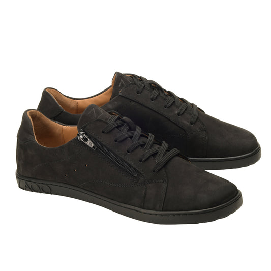 Der QOMFY Wide Black von ZAQQ ist ein Paar schwarzer Low-Top-Sneaker mit Schnürsenkeln und seitlichen Reißverschlüssen, mit einem glatten matten Finish und der markanten strukturierten ZAQQ SNEAKER-Sohle. Diese Sneaker sind fachmännisch aus luxuriösem Veloursleder gefertigt und haben eine raffinierte hellbraune Innenseite für einen zusätzlichen Hauch von Eleganz.