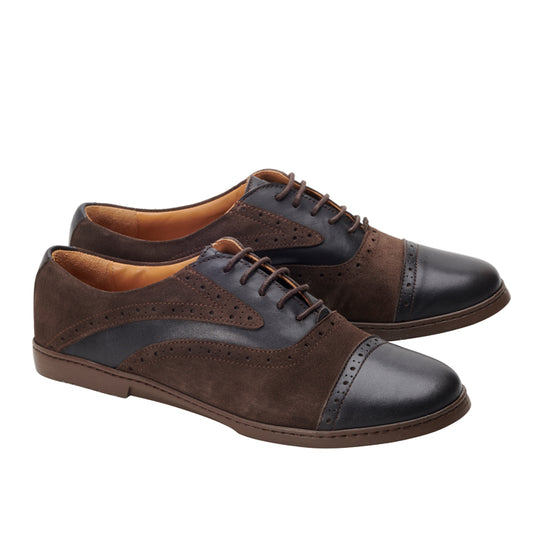 Ein Paar QENTLE Dark Brown von ZAQQ aus feinem Glanzleder mit exquisiten Brogue-Details. Diese Lederschuhe haben Schnürsenkel und einen niedrigen Absatz, die elegant nebeneinander auf weißem Hintergrund angeordnet sind.