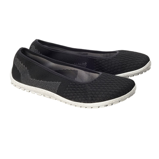 Ein Paar schwarze Slipper SUQAR von ZAQQ mit strukturiertem Strickdesign mit Sneakersohle für ein Barfußgefühl und weißen Gummisohlen, nebeneinander positioniert und für einen femininen Look leicht nach rechts geneigt.