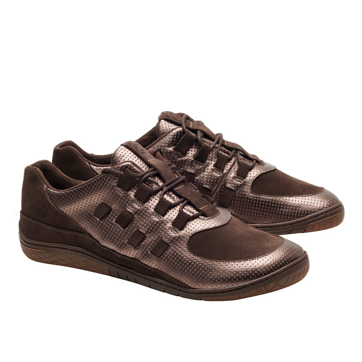 Wir präsentieren die BRISQ Bronze-Sneaker von ZAQQ: ein Paar braune, strukturierte Schuhe mit elegantem Design und sichtbaren Nähten. Sie zeichnen sich durch markante BRISQ Bronze-Akzente aus und zeigen ein einzigartiges Muster auf dem Obermaterial und passende Schnürsenkel, die sich alle vor einem schlichten weißen Hintergrund abheben.