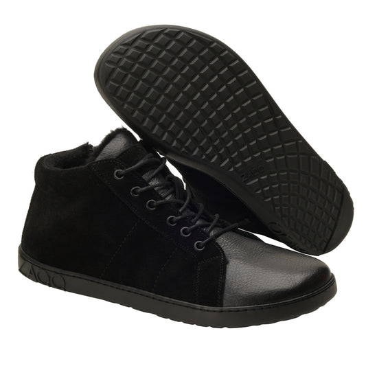 Präsentiert wird ein Paar ZAQQ OMSQ Mid Winter Black High-Top-Sneaker mit Schnürsenkeln, wobei ein Schuh aufrecht steht, um die Seiten- und Vorderansicht zu zeigen, während der andere auf der Seite liegt, um das strukturierte Sohlenmuster zu zeigen, das für einen ähnlichen Komfort wie ein Barfußschuh konzipiert ist.