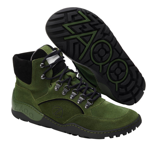 Wir präsentieren die ZAQQ TERRAQ Green Waterproof Wanderstiefel aus Veloursleder. Diese Stiefel haben schwarze Schnürsenkel und eine dicke schwarze Sohle mit einem auffälligen geometrischen Muster. Das Markenlogo ist sowohl an der Seite als auch an der Sohle deutlich zu sehen. Sie sind für raue Abenteuer konzipiert und verfügen über Metallösen und Kontrastnähte.