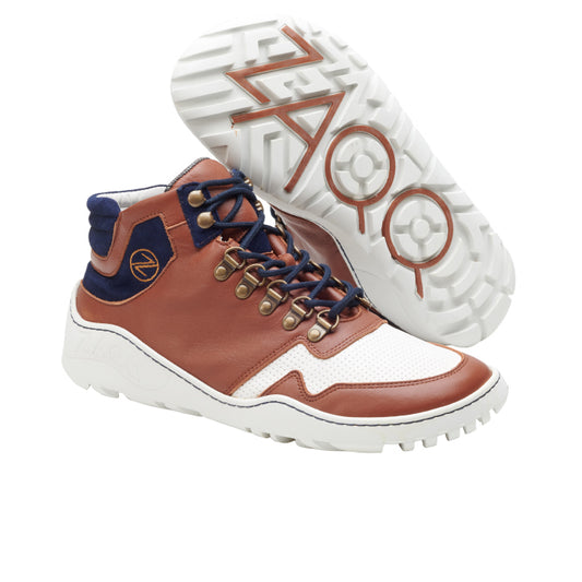 Ein Paar stylische High-Top-Sneaker in Braun und Weiß, akzentuiert mit blauen Details und schwarzen Schnürsenkeln, die an das ZAQQ VAQATION Navy Waterproof-Design erinnern. Die Sohlen weisen markante Muster und Markenzeichen auf. Diese Outdoor-Schuhe werden sowohl von der Seite als auch von unten präsentiert.