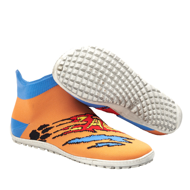 Wir präsentieren den SOQQ Cat Blue von ZAQQ: Diese orangefarbenen Hallenfußballschuhe bestechen durch ein lebendiges Grafikdesign, hervorgehoben durch einen blauen Knöchelkragen und weiße Sohlen mit einem strukturierten Muster für Grip, die ein unvergleichliches Barfußgefühl vermitteln. Die Schuhe werden so präsentiert, dass ein Schuh aufrecht steht und der andere geneigt ist, um das einzigartige Sohlendesign hervorzuheben.