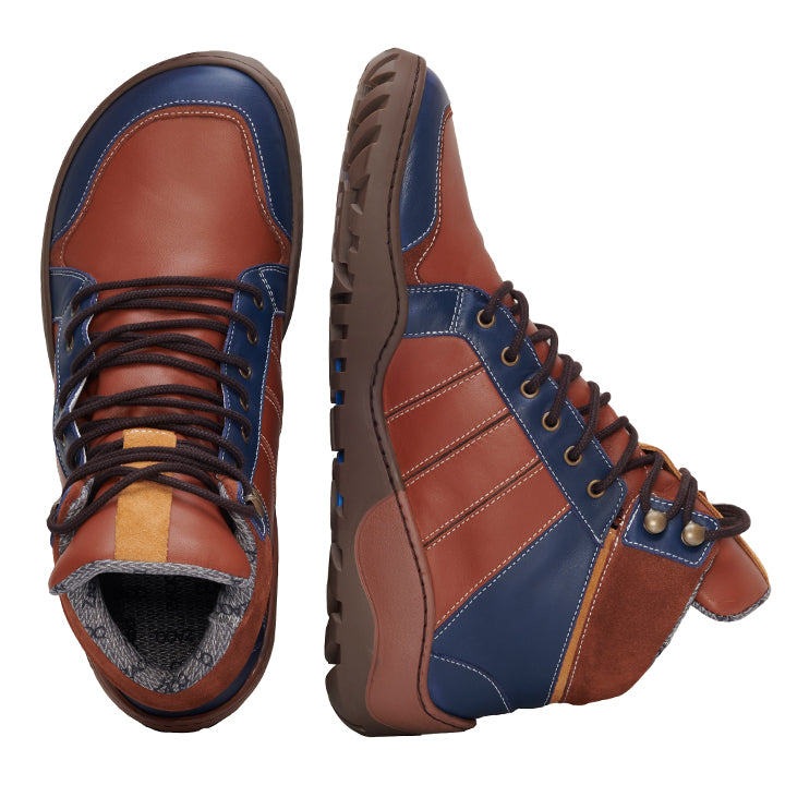 Die Q2 Cognac Waterproof Wanderschuhe von ZAQQ werden elegant aus zwei Perspektiven präsentiert. Der linke Stiefel zeigt die Draufsicht und der rechte Stiefel bietet eine Seitenansicht, die ihre stilvolle Kombination aus braunen und blauen Einsätzen, akzentuiert mit schwarzen Schnürsenkeln und robusten Sohlen, hervorhebt. Als Outdoor-Barfußschuh konzipiert, sind sie perfekt für Abenteurer.