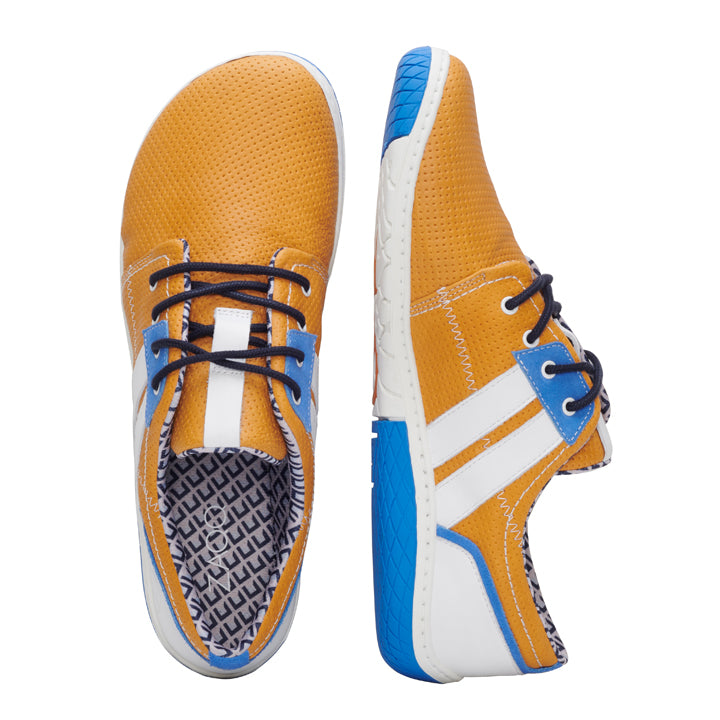 Die QAPETOWN Orange Sneaker von ZAQQ zeigen ein schickes Design mit orangefarbenem perforiertem Nappaleder-Obermaterial und sind mit blauen und weißen Details an den Seiten versehen, ergänzt durch marineblaue Schnürsenkel. Diese Sneaker verfügen über eine ZAQQ MINIMAL-Sohle mit einem strukturierten Muster, akzentuiert durch einen blauen Rand und eine weiße Basis. Der linke Schuh steht aufrecht, während der rechte auf der Seite liegt.