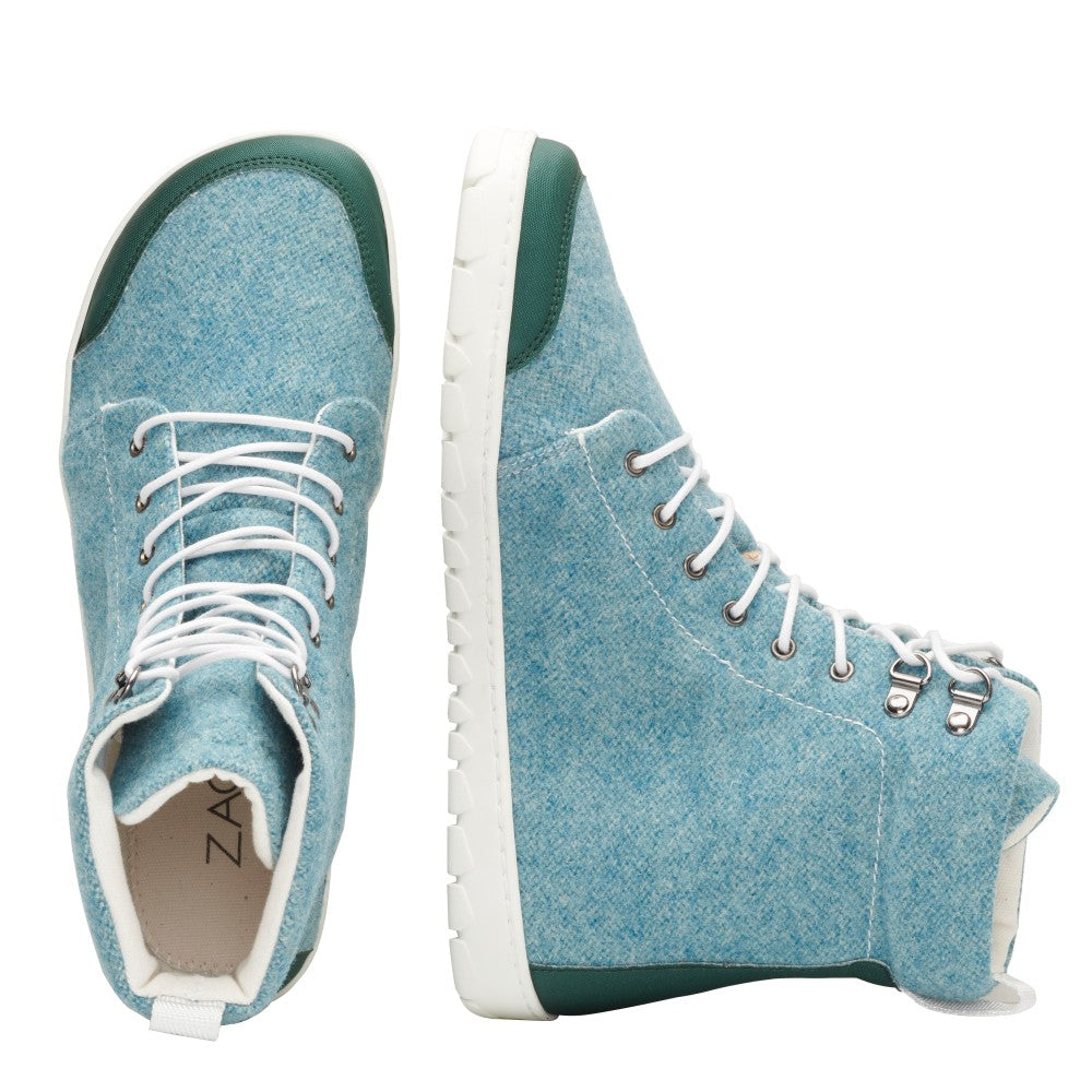 Die QICE Green High-Top-Sneaker von ZAQQ bestechen durch ihre leuchtend blaue Farbe mit weißen Schnürsenkeln und grünen Akzenten. Diese Schuhe sind mit einer Outdoor-Kautschuksohle ausgestattet, die von oben und von der Seite zu sehen ist und ihre robuste weiße Sohle hervorhebt, die für jedes Abenteuer geeignet ist.