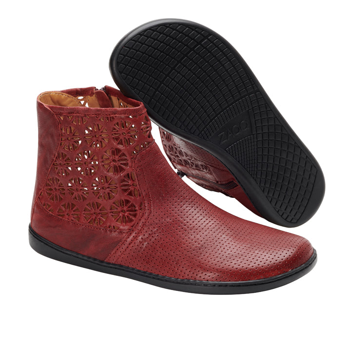 Die QYLIE Bordeaux Lederstiefeletten von ZAQQ bestechen durch aufwendige florale Cut-Out-Designs und schwarze Gummisohlen. Ein Stiefel steht aufrecht, während der andere angewinkelt ist, um das Sohlenmuster zu zeigen. So werden Stil und Komfort perfekt miteinander kombiniert, ähnlich wie bei einem Barfußschuh.