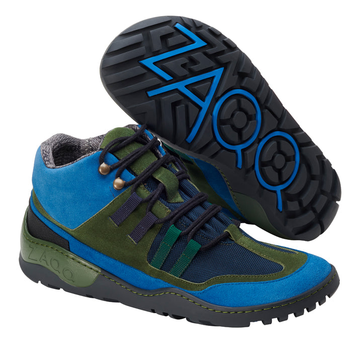 Die ESQAPE Blue Green Waterproof Wanderschuhe von ZAQQ präsentieren eine lebendige Farbpalette mit Blau-, Grün- und Schwarztönen. Ein Schuh steht aufrecht, der andere liegt auf der Seite. Sie heben eine strukturierte Sohle mit blauem Akzent hervor, die mit der ZAQQ TERRA Sohle versehen ist. Das robuste Design wird durch robuste Schnürsenkel abgerundet.