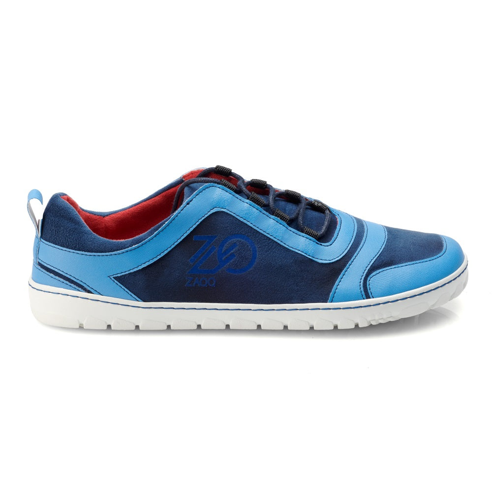 Der SQILL Ocean von ZAQQ ist ein superleichter Sneaker in Blau- und Hellblautönen mit weißer Sohle, seitlichem Logo und schwarzen Schnürsenkeln. Er verfügt über ein rotes Innenfutter und eine praktische Fersenlasche für bequemes Tragen. Als veganer Barfußschuh sorgt er für Komfort und ist zugleich umweltfreundlich.