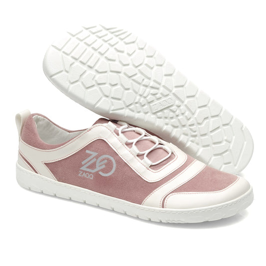 Die SQILL Rose von ZAQQ sind lässige Sneaker aus veganer Mikrofaser. Sie haben eine strukturierte weiße Sohle und tragen das Logo der Marke an der Seite. Die Sneaker sind in einem rosa-weißen Farbschema mit weißen Schnürsenkeln erhältlich, wobei ein Schuh aufrecht steht und der andere auf der Seite liegt.