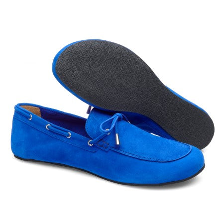 Ausgestellt wird ein Paar FLIQ Blue Loafer von ZAQQ. Ein Schuh liegt auf der Seite und zeigt die schwarze Gummisohle, während der andere aufrecht steht und ein Schnürsenkeldetail an der Oberseite hervorhebt.