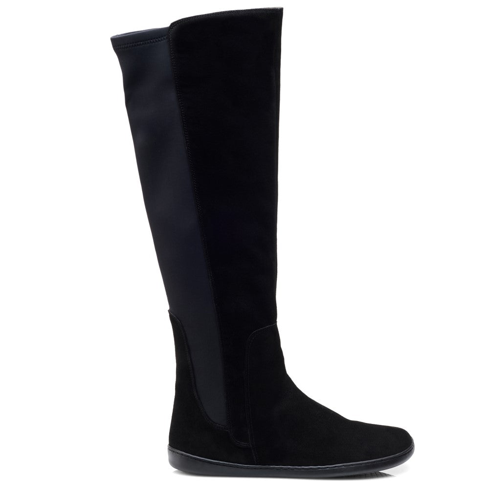 Der kniehohe Stiefel QATCH Velours Black von ZAQQ weist eine flache Sohle und ein wildlederähnliches Finish auf, das seine elegante Silhouette auf weißem Hintergrund betont. Dieser modische Barfuß-Stiefel ist mit einem atmungsaktiven Innenfutter ausgestattet, das Komfort und Atmungsaktivität gewährleistet.